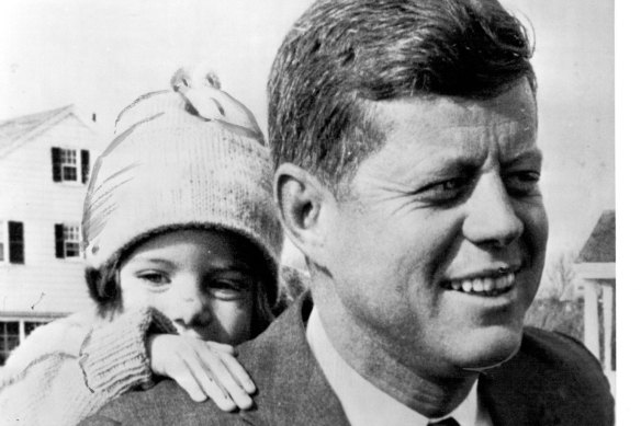 Caroline Kennedy, almost three, peeps over her father John F Kennedy’s shoulder. 