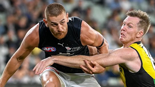 Liam Jones kicks clear despite pressure from Jack Riewoldt.