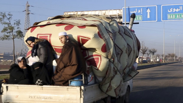 A family with their goods loaded on a truck drives fleeing Idlib province. The UN says that some 60,000 Idlib residents have been displaced in recent weeks by a Russia-backed government offensive.