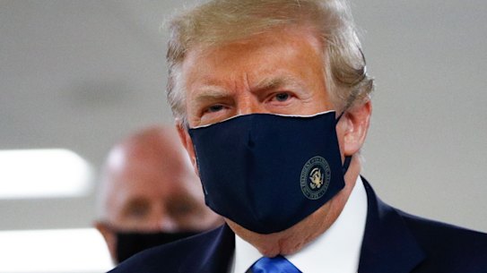President Donald Trump wears a mask as he walks down the hallway during his visit to Walter Reed National Military Medical Centere.