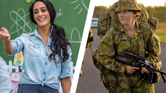 An Ethnic teacher is leading a class of elementary school children. There are various posters on the wall, and drawings on the chalkboard. Students are putting up their hands to answer a question.
