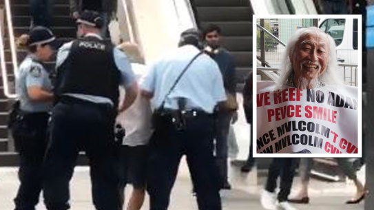 Sandwich board activist Danny Lim is arrested at Barangaroo.