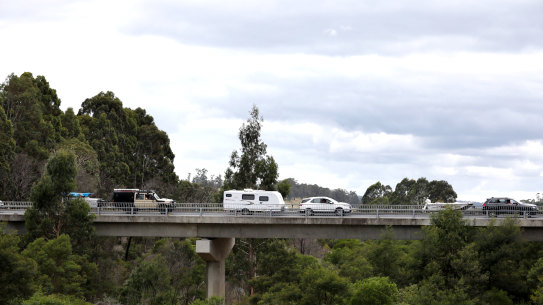 Cars queue to enter Victoria from NSW on Friday at the Genoa border crossing checkpoint.