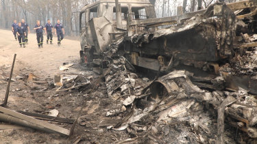 The firefighters return to the site where their trucks were overrun.