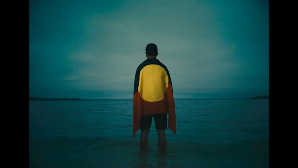 Latrell Mitchell is draped in the Aboriginal flag in the ad.