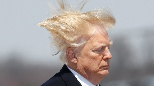 US President Donald Trump's blond hair gets swept up in the wind as he boards Air Force One en route to West Virginia as seen in a screen grab taken from video.