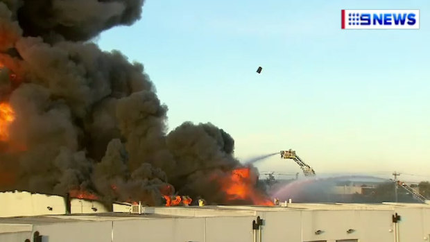 A chemical drum can be seen flying through the air above the inferno on Friday. 