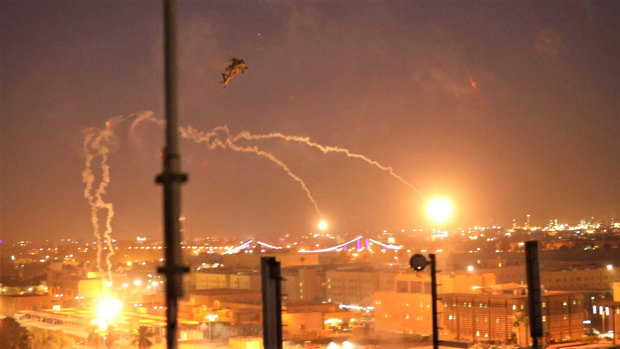 A US army Apache helicopter launches flares as a show of presence while conducting flights over the US Embassy in Baghdad, Iraq.