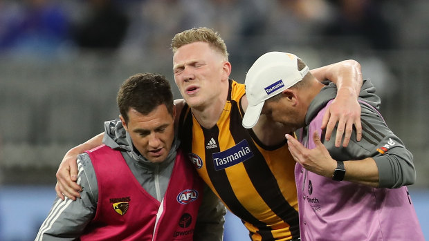 James Sicily is assisted from the field during Hawthorn's loss to West Coast.