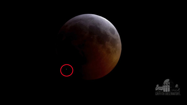 This image from video provided by Griffith Observatory in Los Angeles shows an impact flash on the moon, circled bottom left, during the lunar eclipse which started on Sunday evening. Scientists say it appears a rock from a comet slammed into the moon. 