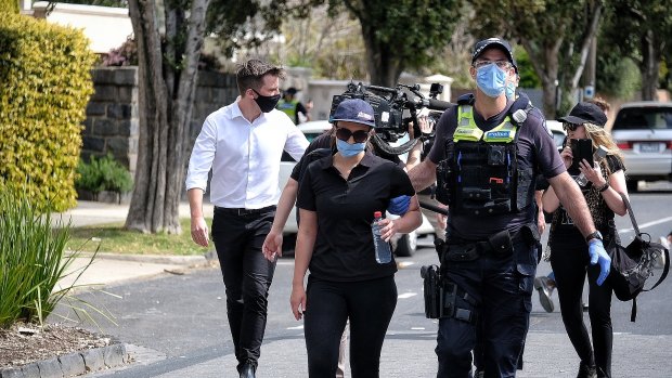 A woman is led away by police in Elsternwick