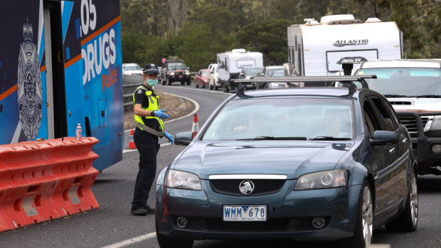 Police stop motorists at a checkpoint in Genoa as they enter Victoria from NSW. 