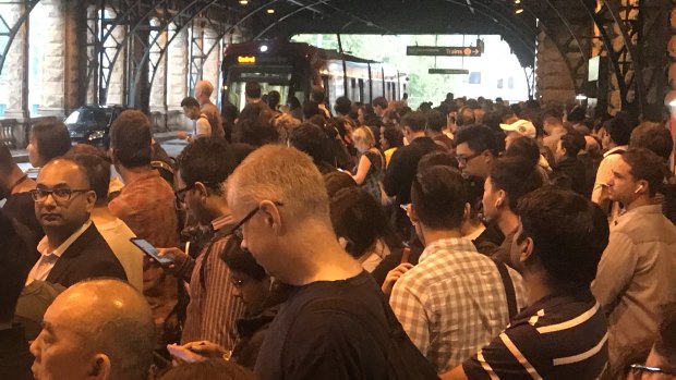 Commuters queued at the light rail stop at Central Station due to wet weather.