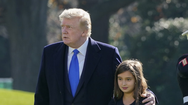 US President Donald Trump walks with his granddaughter Arabella Kushner on the South Lawn of the White House in Washington.