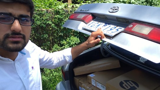Vocational education salesman "Hamza" with a car boot load of laptops at a housing commission street in Queensland in 2016.