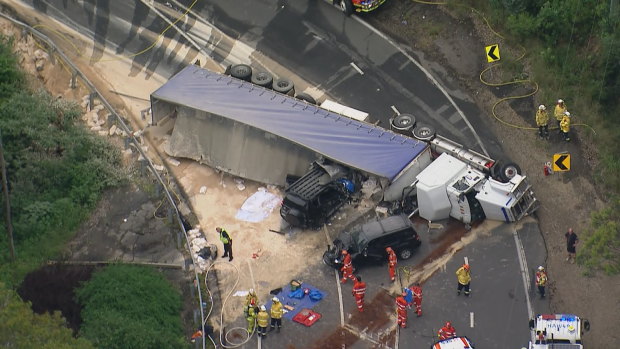 Three people were injured and a woman trapped after a truck rolled over on Bells Line of Road in Kurrajong Heights. 