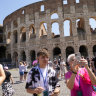 Visitors take photos of the ancient Colosseum in Rome.