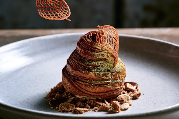 Pear monaka, a pear-shaped croissant brushed with amaretto syrup and filled with pear compote and hojicha ice-cream. It rests on a bed of dulcey whipped ganache, ginger caramel and brown butter crumble.
