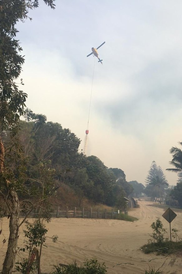 A helicopter drops water on the blaze near Happy Valley on Monday.