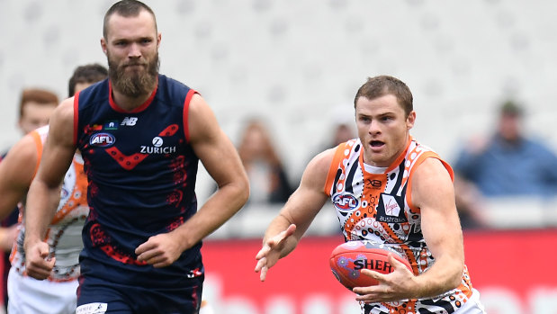 Shaw thing: Melbourne's Max Gawn looks on as former Magpie Heath Shaw steams forward for the Giants.