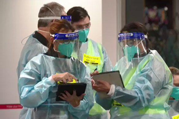 Authorised officers check the identification of passengers arriving at Melbourne Airport  in June.