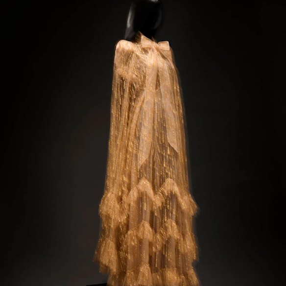 The Weddings and a Funeral gold gown features a sheer, metallic tiered skirt.
