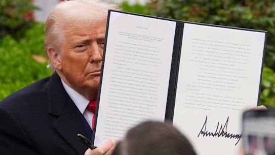 President Donald Trump holds a signed executive order during an event to announce new tariffs in the Rose Garden of the White House, Wednesday, April 2, 2025, in Washington.