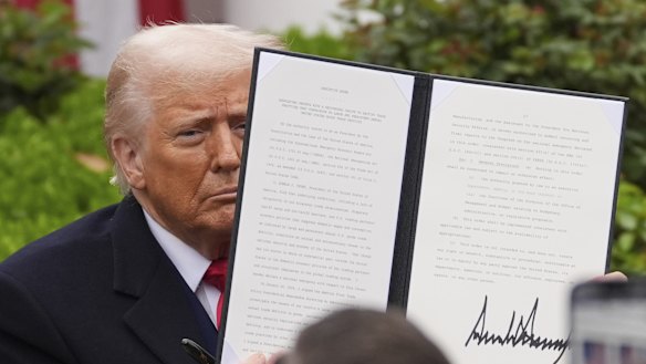 President Donald Trump holds a signed executive order during an event to announce new tariffs in the Rose Garden of the White House on Wednesday.