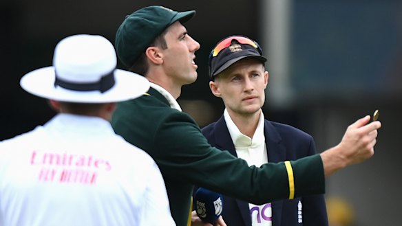 Australian captain Pat Cummins tosses the coin as England captain Joe Root calls.