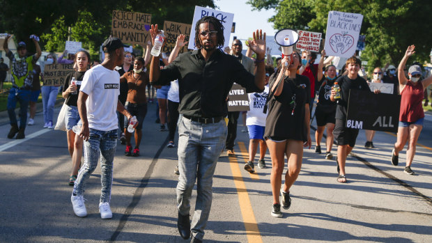 Joshua Benton leads protesters as they march down Main Street during a rally in Broken Arrow, Oklahoma. 