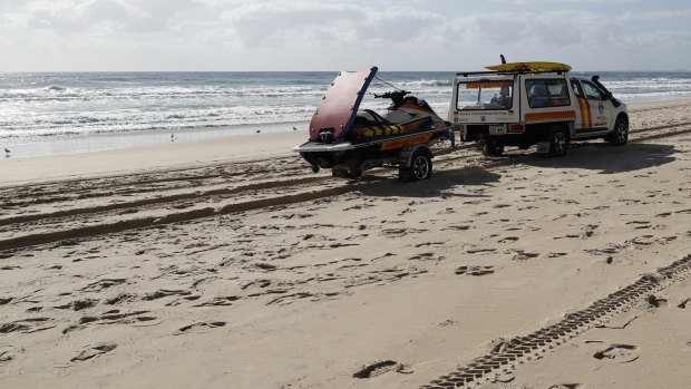 A surf lifesaving crew drives past the scene at Surfers Paradise where a baby's body was found.