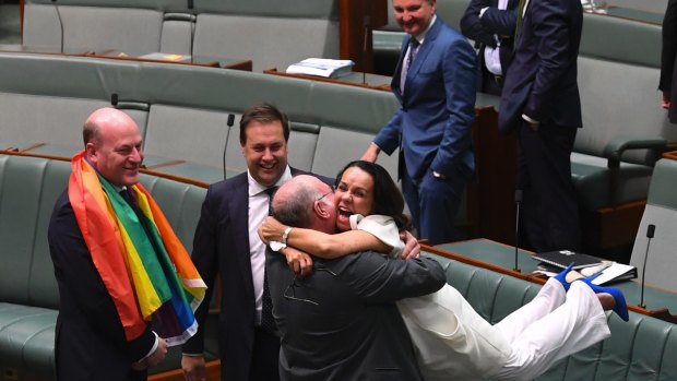 Liberal MP Warren Entsch lifts Labor MP Linda Burney into the air after the same-sex marriage vote in the House of Representatives.