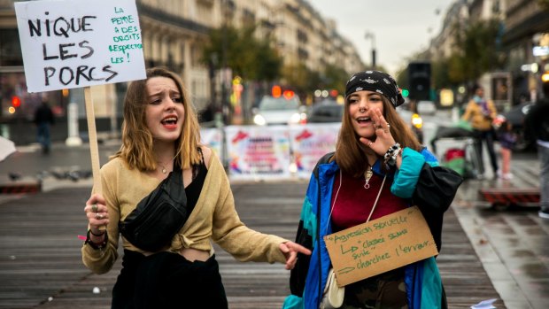 Protesters hold placards and shout slogans as they take part in a gathering against gender-based and sexual violence on the Place de la Republique square in Paris.