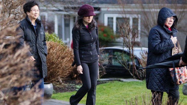 Meng Wanzhou, centre, leaves her home while out on bail in Vancouver, Canada.