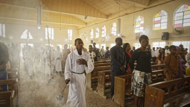 An altar boy swings the thurible of incense during a morning service at the Saint Charles Catholic Church, the site of a 2014 bomb attack blamed on Islamic extremist group Boko Haram in Kano, northern Nigeria.