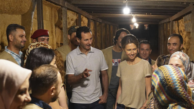 Syrian President Bashar al-Assad, centre left, and his wife Asma, centre right, talk with Syrian artists during their visit to one of the tunnels dug by rebels while they were under siege in Jobar, near the capital Damascus.