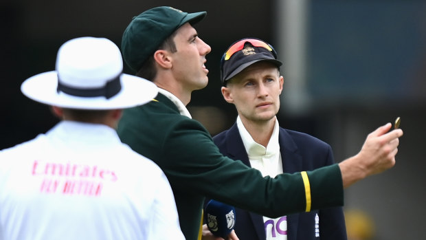 Australian captain Pat Cummins tosses the coin as England captain Joe Root calls.