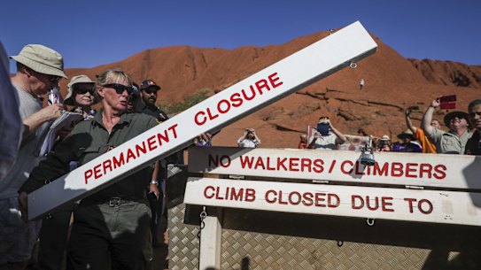 Ranger Lynda Wright places the new sign of the permanent closure of the Uluru climb.