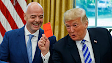 President Donald Trump holds up a red card during a meeting with FIFA president Gianni Infantino.