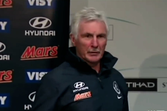 Screenshot of Mick Malthouse walking out of a press conference in 2014.