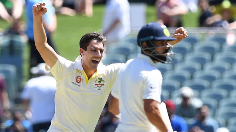 Pat Cummins celebratesVirat Kohli's wicket as the batsman stands at the crease after Usman Khawaja's catch.