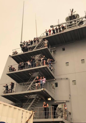 Mallacoota residents and tourists aboard HMAS Choules as it leaves the Victorian coastal town for Melbourne. 