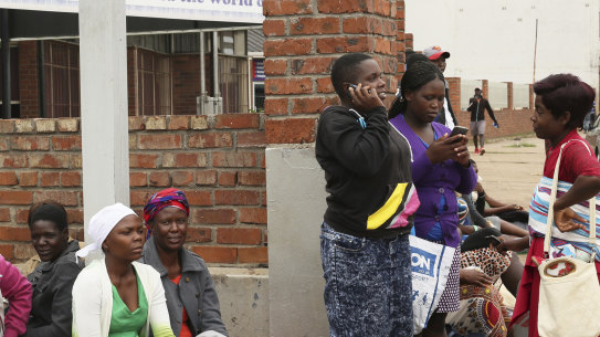 People wait in a queue for cooking gas at a garage in Harare on Wednesday.