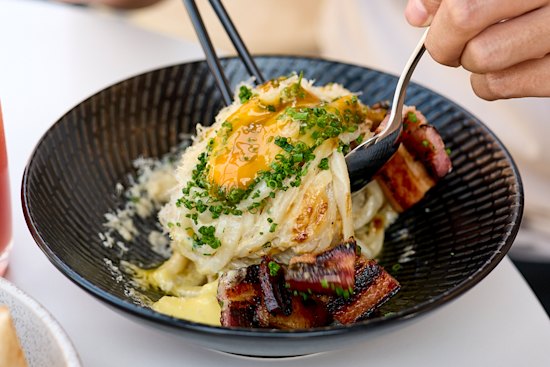 Sana’s udon carbonara comes with charred kaiserfleisch, smoked dashi, a soft egg and heaps of black pepper. 