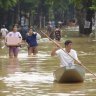 People carrying belongings wade in a flooded street in the aftermath of Typhoon Yagi in Hanoi, Vietnam.