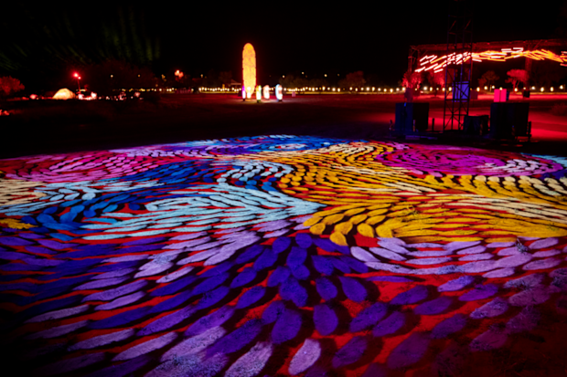Artist Daphne Marks' work 'Yalka Tjukurrpa - Bush Onion Dreaming' projected onto the floor in a rainbow display.