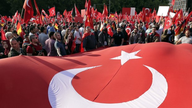 Protesters hold a national flag of Turkey in front of the Brandenburg gate in Berlin, Germany, in 2016 as they demonstrate against a resolution of the German Parliament recognising the Armenian genocide. 