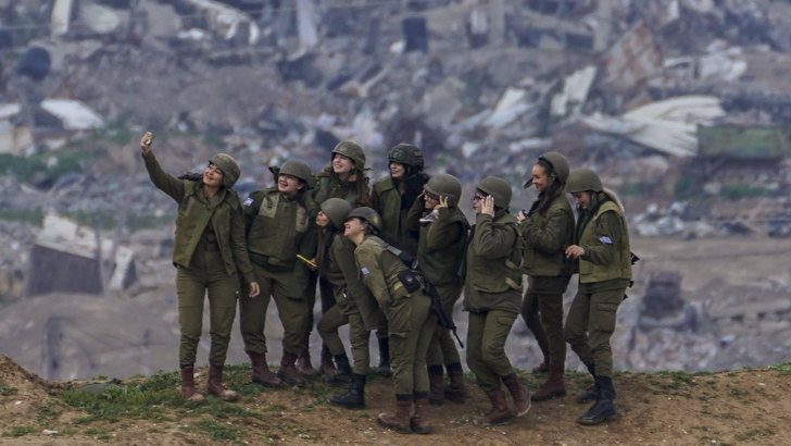 Israeli female soldiers pose for a photo on a position on the Gaza Strip border, in southern Israel.