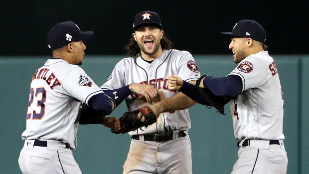 Outfielders Michael Brantley, Jack Marisnick and George Springer celebrate Houston's win in game four.
