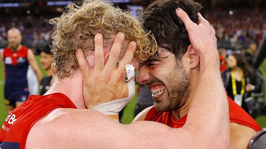 Demons stars Clayton Oliver and Christian Petracca celebrate their drought-breaking flag win.